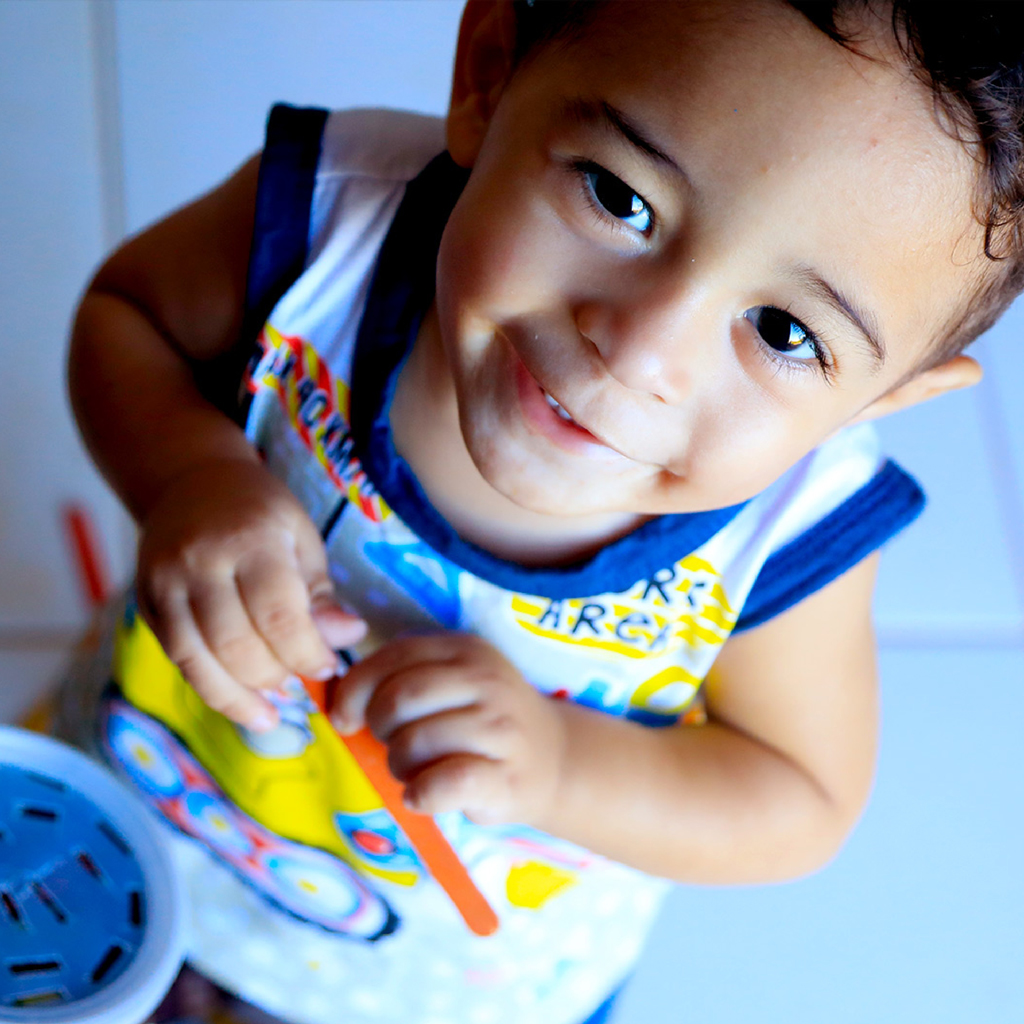 Criança sorrindo e olhando para a câmera